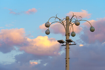 A street lamp in the sky with white cloud at sunset