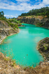 A striking turquoise lake surrounded by rocky cliffs and lush vegetation