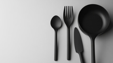 Stylish black kitchen utensils arranged neatly on a plain surface ready for culinary preparation