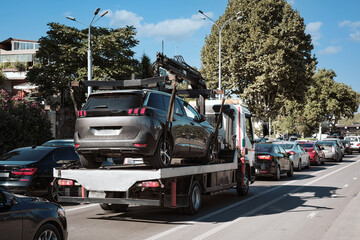 A car tow truck takes an SUV to a repair station.