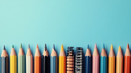 Fresh notebooks and sharpened pencils placed in an orderly fashion against a cheerful pastel backdrop Stock Photo with side copy space