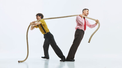Two men engaged in tug of war, one pulling rope with all his strength while other in resistance, showing competitive spirit. Concept of teamwork challenge, retro style, lifestyle situation.