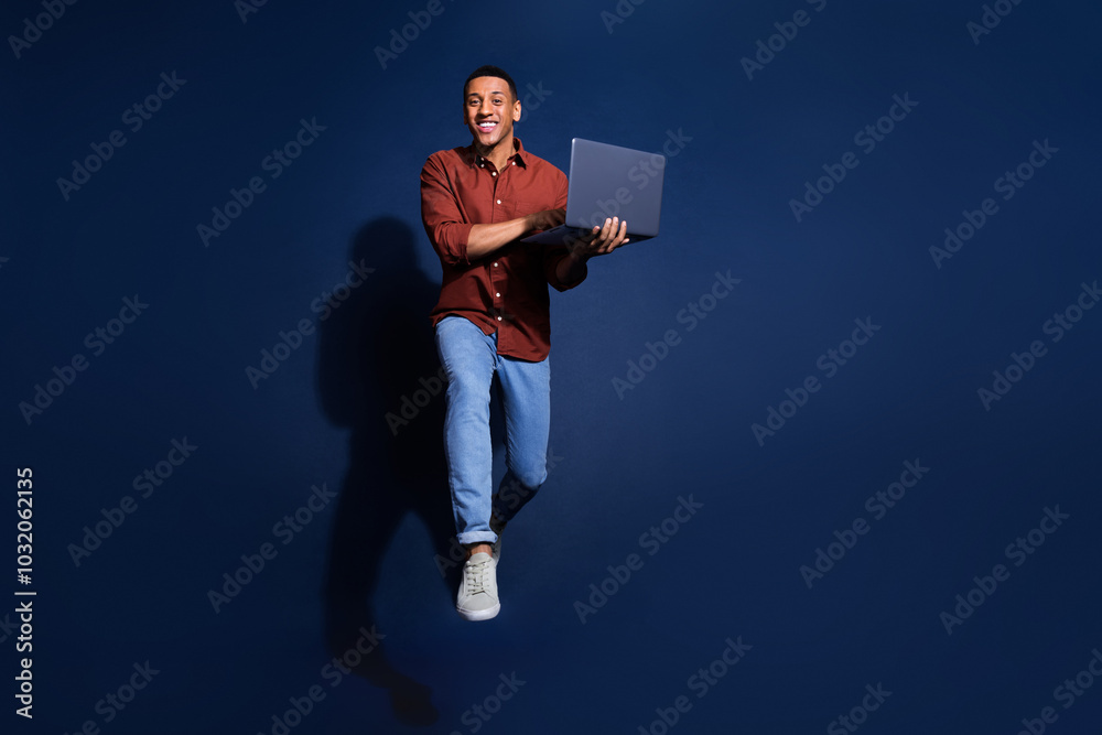 Canvas Prints Full length photo of cheerful positive guy dressed brown shirt jumping communicating device isolated blue color background