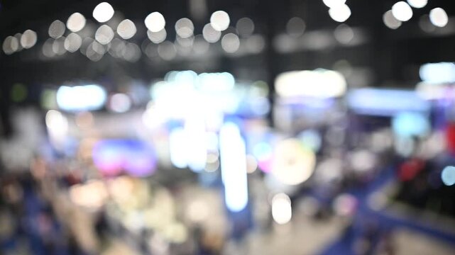 Intentionally blurred footage of people visiting pavilions and booths during a business trade fair 