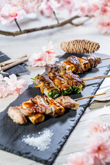 Japanese cuisine grilled beef and veg roll skewers with sakura flowers