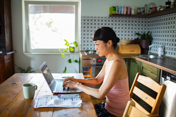 Stressed woman reviewing bills and financial documents at home