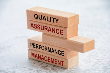 Quality Assurance and Performance Management text on wooden blocks. Business and quality assurance...