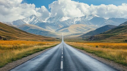 Naklejka premium Winding Asphalt Road Through Mountain Valley With Snow Capped Peaks