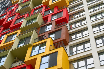 Modern colorful apartment building featuring bold geometric designs and varying balcony styles in...