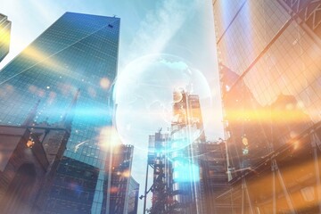 A low angle view of glass skyscrapers with a translucent globe in the center, illuminated by warm sunlight.