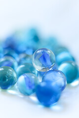 blue glass marbles on a white background close-up, macro photography