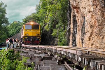 Trains running on death railways track crossing kwai river in kanchanaburi thailand this railways important destination of world war II history builted by soldier prisoners..