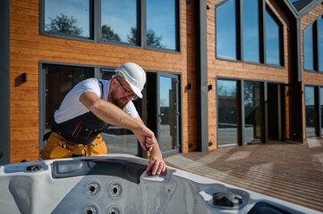 Plumber installing hot tub. Spa technician performing hot tub. Bathtub plumbing. Plumber fixing spa...