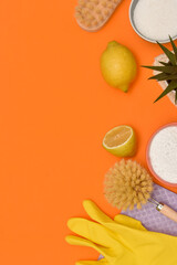 Zero waste eco friendly cleaning concept. wooden brushes, lemon, baking soda, percarbonate, gloves on orange background