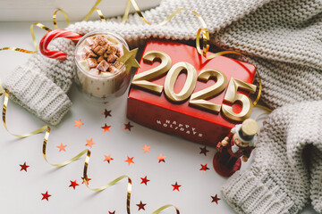 Happy new year 2025. A vibrant red gift box displaying the message of Happy Holidays sits beneath...