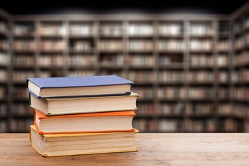 stack of reading books on table against library background