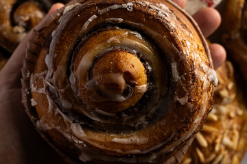 Un rollo de canela en primer plano, resaltando su textura suave y glaseado. Este dulce clásico combina la suavidad del pan con el sabor especiado de la canela.