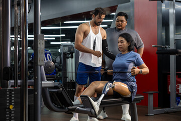 Asian woman with prosthetic leg from amputation from doing weight training workout exercise using...