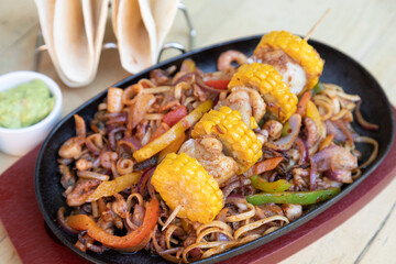 Seafood kebabs on stir fried spiced vegetable served with wraps