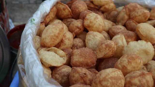 Close-up footage of crispy golgappe at a street stall, showcasing the vibrant colors and textures of this popular Indian snack