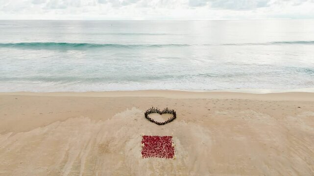 Drone Heart of roses petals on tropical sandy beach. Nobody. Love concept set up wedding ceremony. Wedding decor beach seaside