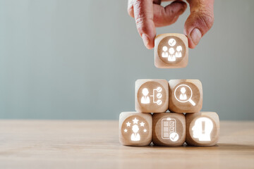 Wooden blocks with HR icons symbolize assessment center concepts for business evaluation and recruitment processes.