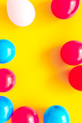 Colorful balloons frame on yellow background top-down frame copy space