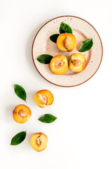 Healthy food. Ripe sliced peaches on plate on white table top-down copy space