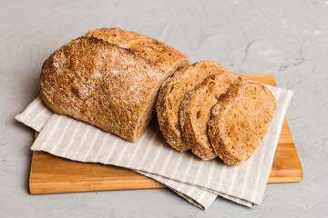 Assortment of freshly sliced baked bread with napkin on rustic table top view. Healthy unleavened bread. French bread slice