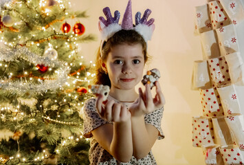 A girl shows a gift from the pocket of a wall advent calendar.