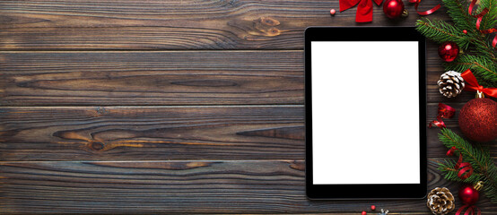 Digital tablet mock up with rustic Christmas decorations for app presentation top view with empty space for you design. Christmas online shopping concept. Tablet with copy space on colored background