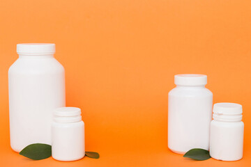 supplement pills with medicine bottle health care and medical top view. Vitamin tablets. Top view mockup bottle for pills and vitamins with green leaves, natural organic bio supplement, copy space
