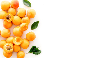 Fruit background with apricots and leaves on white background top view space for text