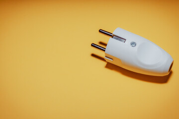 Electrical plug with European standard socket. The concept of electrical equipment. Concept of a day without electricity. Eco-friendly fuels. Yellow background.