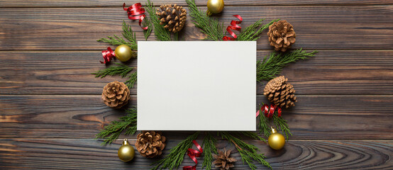 Flat lay Christmas composition. square Paper blank, pine tree branches, christmas decorations on Colored background. Top view, copy space for text