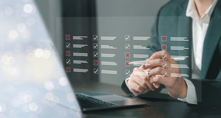 Clipboard task management and monitoring Businessman working on production checklist on laptop computer and filling out online survey forms, online document management concept