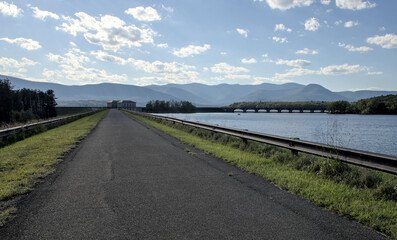 Fototapeta premium arched bridge across the ashokan reservoir in hudson valley upstate new york (nyc drinking water lake pond) summer day public park promenade walking hiking biking cycling trail path rail