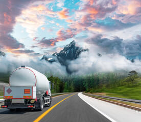 Fuel truck on a picturesque road. A silver tank truck transports fuel.