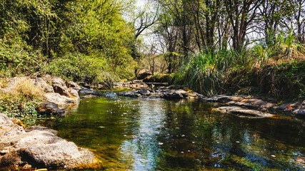 Landscape view of Amboy fresh water river surrounded by a green forest near Villa Amancay, Cordoba