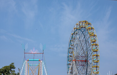 Ferris Wheel or Joint wheel ride running under blue sky on fair ground during the annual dussehra fair.