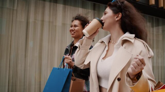Two young women walking and talking after shopping spree