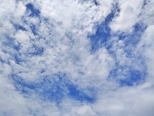 The clear blue sky with scattered white clouds evokes a sense of calmness and teanquilitty
