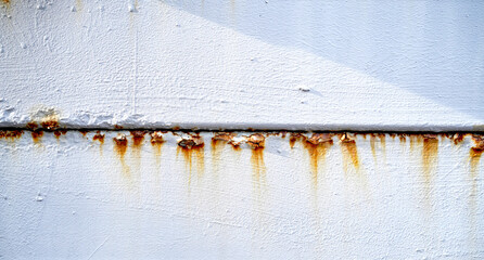 Rust strip in the middle of the iron sheet coated with white paint. The pattern of grunged rust on...
