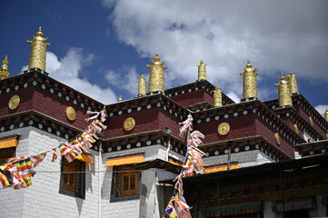 Explosion of colors and objects - the mixture of ShangRi-La architecture, prayer flags, red colors of the walls, blue sky and white structures