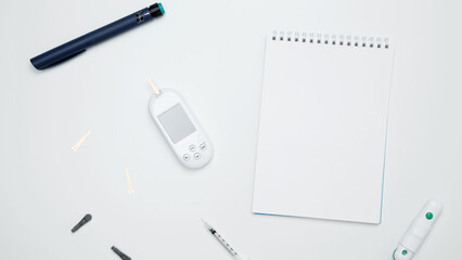 Diabetes concept with glucometer, syringe pen with insulin, blood test strips. Concept of worldwide diabetes awareness. Top view. Copy space