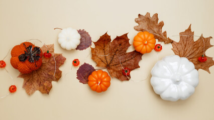 Autumn composition with maple leaves, decorative pumpkins and candles. Top view. Copy space