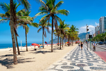 Ipanema beach with palms and mosaic of sidewalk in Rio de Janeiro, Brazil. Ipanema beach is the...