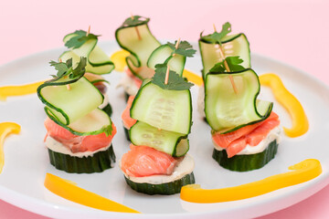 Canapes without Bread with Fresh Salmon, Cucumber and Cream Cheese on White Plate. Easy Breakfast. Diet Food. Quick and Healthy Sandwiches. Healthy Snacks with Tasty Fillings