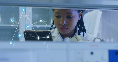 Image of network of connections over african american female scientist working in lab