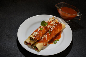 Meat pancake on a white plate with red sauce, dark background